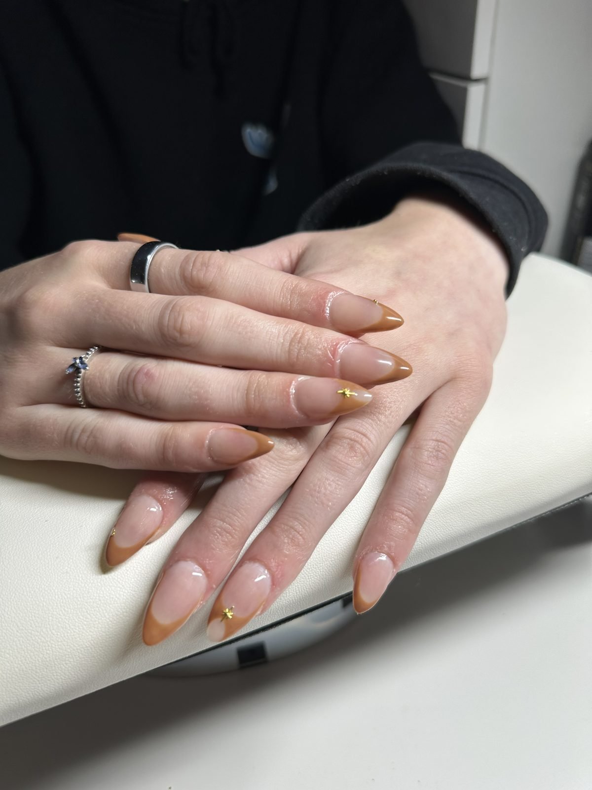 Warm caramel French acrylic set with fine gold star detailing
